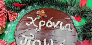 Μια στρογγυλή βασιλόπιτα καλυμμένη με γυαλιστερή σοκολάτα και διακοσμημένη με λευκό γλάσο για το νέο έτος.