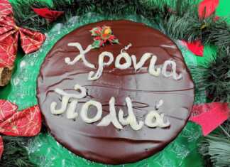 Μια στρογγυλή βασιλόπιτα καλυμμένη με γυαλιστερή σοκολάτα και διακοσμημένη με λευκό γλάσο για το νέο έτος.