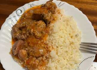 Μια κατσαρόλα με αχνιστό, κάτασπρο και σπυρωτό ρύζι, έτοιμο να σερβιριστεί ως συνοδευτικό.