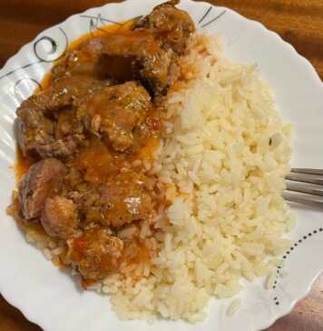 Μια κατσαρόλα με αχνιστό, κάτασπρο και σπυρωτό ρύζι, έτοιμο να σερβιριστεί ως συνοδευτικό.