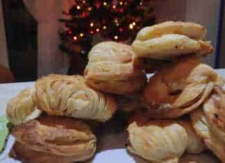 Ένα πιάτο με χρυσαφένια, ροδοκοκκινισμένα μικρά τυροπιτάκια με φέτα, έτοιμα για σερβίρισμα.