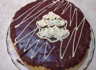 Ένα εντυπωσιακό κέικ Marlenka με πολλές λεπτές στρώσεις μελιού και κρέμας, καλυμμένο με θρυμματισμένο κέικ και καρύδια.