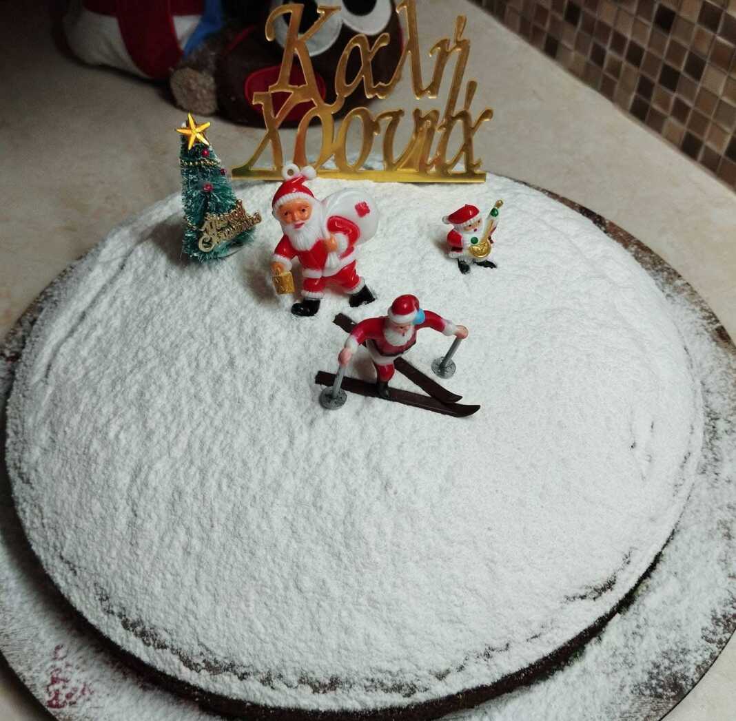 Μια αφράτη βασιλόπιτα κέικ πασπαλισμένη με ζάχαρη άχνη, στολισμένη για την αλλαγή του χρόνου.