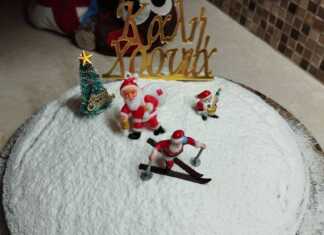 Μια αφράτη βασιλόπιτα κέικ πασπαλισμένη με ζάχαρη άχνη, στολισμένη για την αλλαγή του χρόνου.