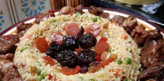 Ζουμερά κομμάτια χοιρινού με μελωμένη σάλτσα δαμάσκηνου, σερβιρισμένα δίπλα σε πολύχρωμο πιλάφι με λαχανικά.