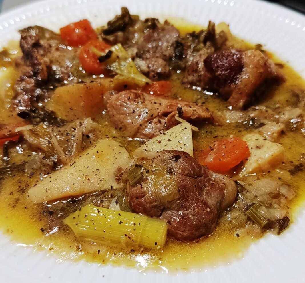 Ένα πιάτο με παραδοσιακό χοιρινό με σέλινο και σελινόριζα, περιχυμένο με πλούσιο αυγολέμονο, με κομμάτια χοιρινής σπάλας και μπούτι.