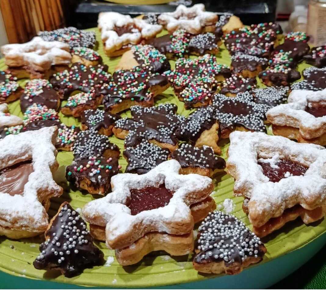 xristougeniatika mpiskotakia Διαφορετικά χριστουγεννιάτικα μπισκότα (αστέρια, δέντρα, κ.λπ.) γεμιστά με μαρμελάδα ή με γλάσο σοκολάτας, σερβιρισμένα σε γιορτινή πιατέλα.