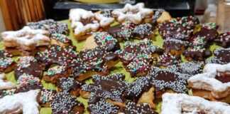 Διαφορετικά χριστουγεννιάτικα μπισκότα (αστέρια, δέντρα, κ.λπ.) γεμιστά με μαρμελάδα ή με γλάσο σοκολάτας, σερβιρισμένα σε γιορτινή πιατέλα.