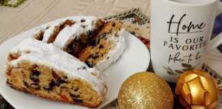 Ένα παραδοσιακό γερμανικό Stollen τυλιγμένο σε ζάχαρη άχνη, κομμένο σε φέτες για να δείξει τα αποξηραμένα φρούτα και τους ξηρούς καρπούς στο εσωτερικό.