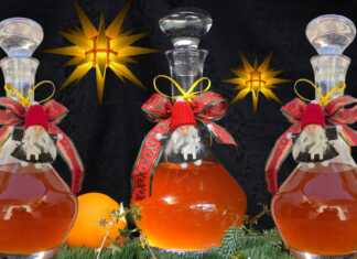 Χειροποίητο λικέρ πορτοκάλι με κορμούς κανέλας και γαρίφαλα μέσα σε μπουκάλι γυάλινο, με φόντο χριστουγεννιάτικης διακόσμησης.