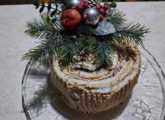 Ένα εντυπωσιακό χριστουγεννιάτικο κέικ κορμός με επικάλυψη σοκολάτας και σχέδια φλοιού δέντρου, στολισμένο γιορτινά.