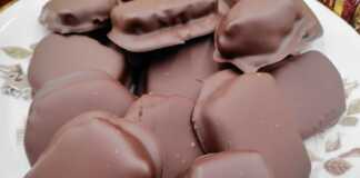 Τετράγωνες καριόκες καλυμμένες με γυαλιστερή σοκολάτα, τοποθετημένες πάνω σε λαδόκολλα.