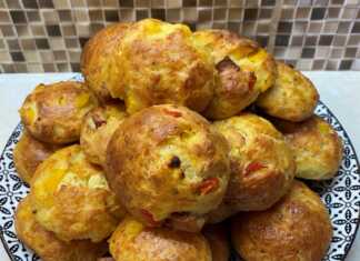 Ένα πιάτο γεμάτο με στρογγυλά ροδοκοκκινισμένα τυροπιτάκια, όπου διακρίνονται κομματάκια από πολύχρωμες πιπεριές στο εσωτερικό τους.