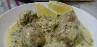 ενα βαθυ πιάτο με λευκά γιουβαρλάκια και καταπράσινα άγρια χόρτα μέσα σε μια πυκνή σάλτσα αυγολέμονο.