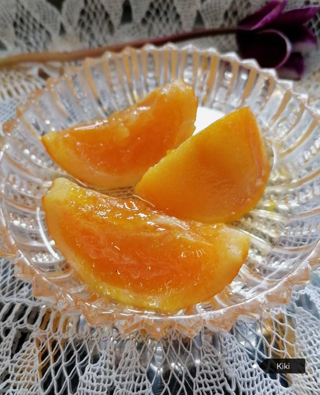 Ένα κρυστάλλινο πιατάκι με χρυσαφένιες φέτες γλυκό κουταλιού πορτοκάλι, λουσμένες σε παχύρρευστο, λαμπερό σιρόπι.