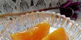 Ένα κρυστάλλινο πιατάκι με χρυσαφένιες φέτες γλυκό κουταλιού πορτοκάλι, λουσμένες σε παχύρρευστο, λαμπερό σιρόπι.