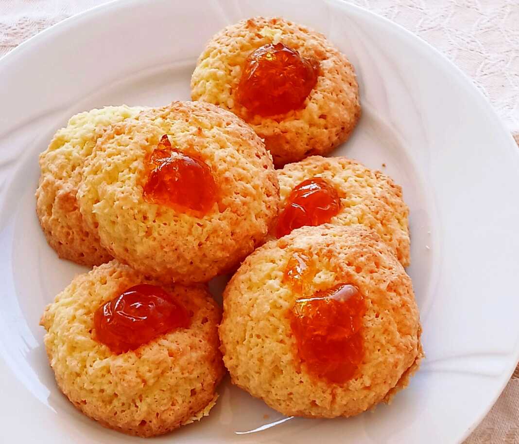 Μικρές χρυσοξανθές καρύδες τοποθετημένες σε δίσκο, διακοσμημένες με κόκκινο κερασάκι στην κορυφή.