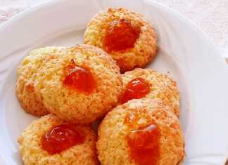 Μικρές χρυσοξανθές καρύδες τοποθετημένες σε δίσκο, διακοσμημένες με κόκκινο κερασάκι στην κορυφή.