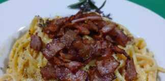 Ένα πιάτο με λιγκουίνι καρμπονάρα, καλυμμένο με τραγανό γκουαντσιάλε και φρεσκοτριμμένο πεκορίνο, που αχνίζει.