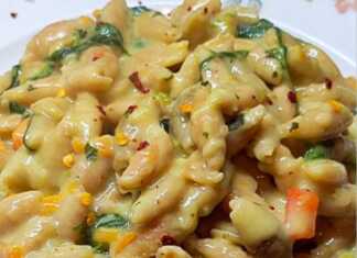 κοχυλάκια κόκκινης φακής μέσα σε κρεμώδη σάλτσα με σπανάκι και τριμμένο καρότο, διακοσμημένο με φρέσκο βασιλικό.