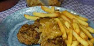 Μια πιατέλα με καλοψημένα κεφτεδάκια καλυμμένα με μια παχύρρευστη σάλτσα από κρεμμύδια και μπύρα, σερβιρισμένα με φρέσκο μαϊντανό.