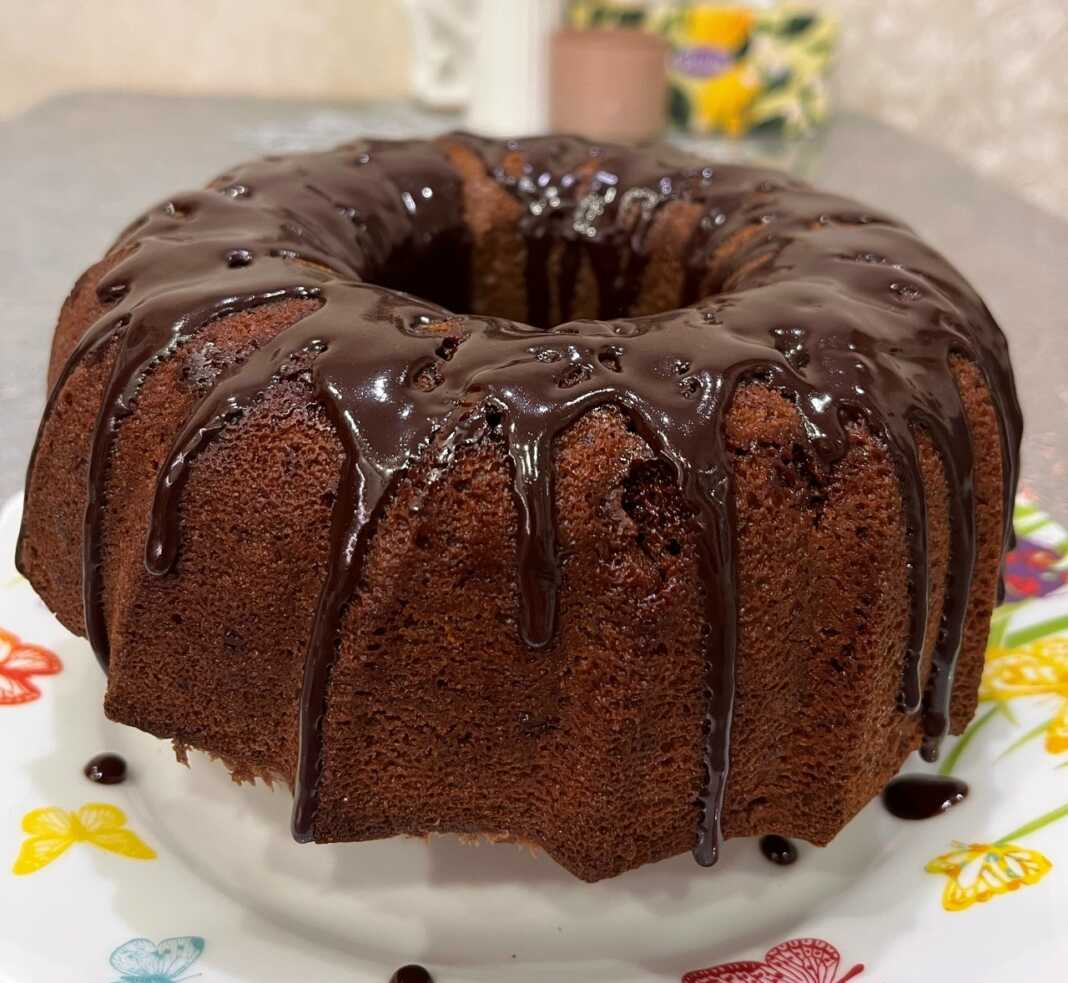 Ένα ψηλό, σοκολατένιο ιταλικό κέικ με τρύπα στη μέση, γαρνιρισμένο με λιωμένη σοκολάτα και τρούφα.