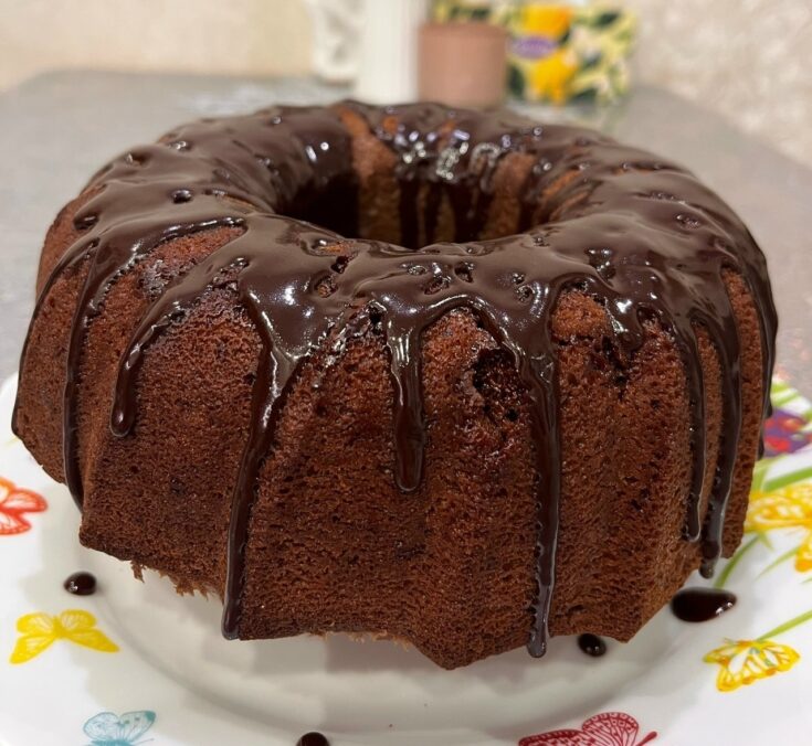 Ένα ψηλό, σοκολατένιο ιταλικό κέικ με τρύπα στη μέση, γαρνιρισμένο με λιωμένη σοκολάτα και τρούφα.