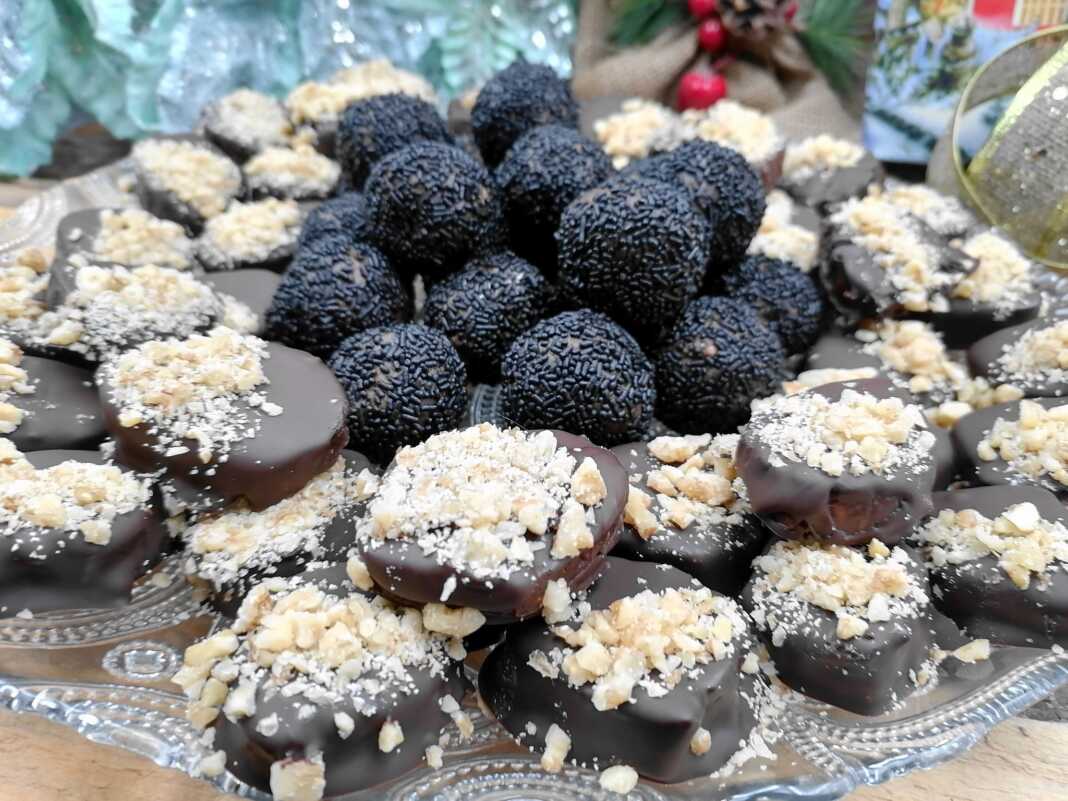 Δίσκος με διάφορα σοκολατένια κεράσματα φτιαγμένα από μελομακάρονα, μερικά καλυμμένα με τρούφα και άλλα με στρώση σοκολάτας και καρύδι.