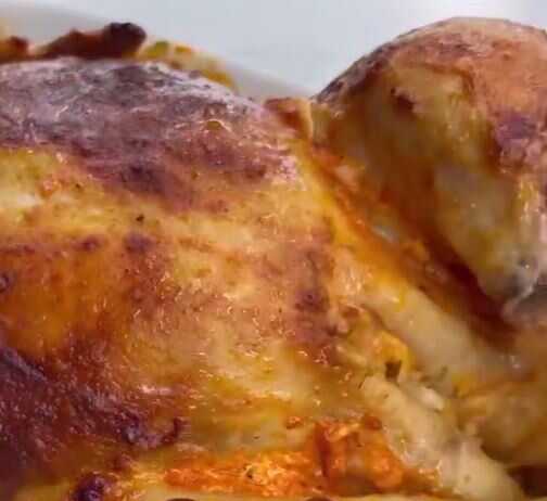 Ολόκληρο ψημένο κοτόπουλο με χρυσαφένια πέτσα περιτριγυρισμένο από μικρές πατάτες baby μέσα σε ένα ταψί.