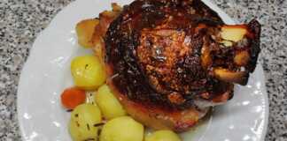 Χοιρινό Κότσι στο Φούρνο με Σιρόπι Ροδιού: Το Μυστικό για την Πιο Τραγανή Πέτσα! Τέσσερα ροδοκοκκινισμένα χοιρινά κότσια με τραγανή πέτσα, σερβιρισμένα με πουρέ πατάτας και σάλτσα.