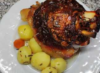 Τέσσερα ροδοκοκκινισμένα χοιρινά κότσια με τραγανή πέτσα, σερβιρισμένα με πουρέ πατάτας και σάλτσα.