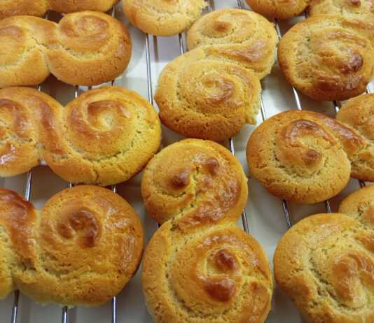 Ένα μεγάλο καλάθι γεμάτο με διάφορα σχέδια από παραδοσιακά πασχαλινά κουλουράκια, γυαλιστερά από το αυγό και καλοψημένα.