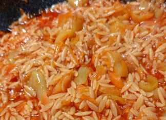 Ένα πιάτο μελωμένο κριθαράκι, κόκκινες και πράσινες πιπεριές, τριμμένο καρότο και πλούσια κόκκινη σάλτσα.