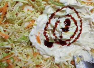 Ένα μπολ με πλούσια λαχανοσαλάτα, στολισμένη με τρίμμα καρότου και ξινόμηλου, σε ένα φωτεινό τραπέζι.