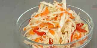 Ένα γυάλινο μπολ γεμάτο με ψιλοκομμένο λάχανο, καρότο και πιπεριές σε μαρινάδα, δίπλα σε ένα μπολ με την ίδια δροσερή σαλάτα.