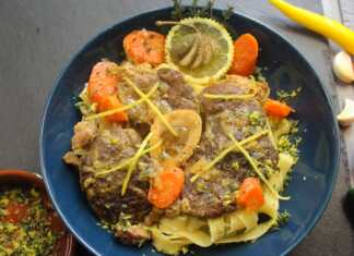 Ένα πιάτο με τρυφερό μοσχαρίσιο οσομπούκο, περιχυμένο με πλούσια λεμονάτη σάλτσα, σερβιρισμένο πάνω σε ζυμαρικά με τριμμένο τυρί.