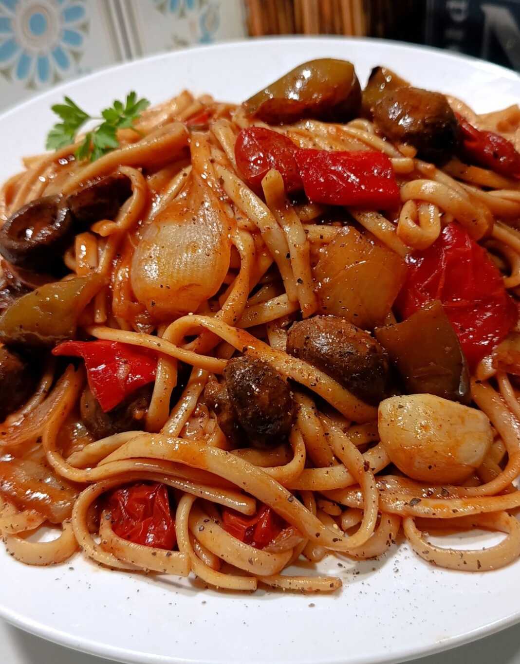 Ένα πλούσιο πιάτο με λιγκουίνι λαχανικών, γεμάτο πολύχρωμες πιπεριές, μανιτάρια, ντοματίνια και τριμμένο βολάκι Τήνου στην κορυφή.