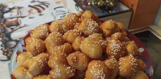 Μια πιατέλα γεμάτη χρυσαφένιους, στρογγυλούς λουκουμάδες, περιχυμένους με άφθονο μέλι και πασπαλισμένους με καβουρδισμένο σουσάμι και κανέλα.