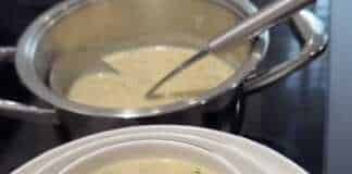 Μια ζεστή και βελούδινη μανιταρόσουπα Alfredo σε λευκό μπολ, γαρνιρισμένη με φρέσκο πιπέρι και ψιλοκομμένα μανιτάρια.