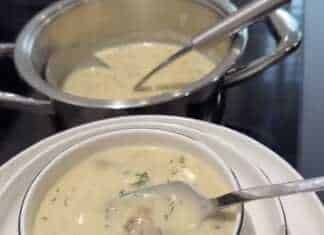 Μια ζεστή και βελούδινη μανιταρόσουπα Alfredo σε λευκό μπολ, γαρνιρισμένη με φρέσκο πιπέρι και ψιλοκομμένα μανιτάρια.