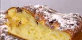 Μια αχνιστή μηλόπιτα σαρλότ , πασπαλισμένη με ζάχαρη άχνη και λιωμένες σταγόνες σοκολάτας, έτοιμη για σερβίρισμα.