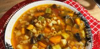 Μινεστρόνε Λαχανικών: Μια Ζεστή Αγκαλιά στο Πιάτο σας! Ενα βαθύ πιάτο με πολύχρωμη σούπα μινεστρόνε που αχνίζει, γεμάτη κομμάτια λαχανικών και κοφτό μακαρονάκι.