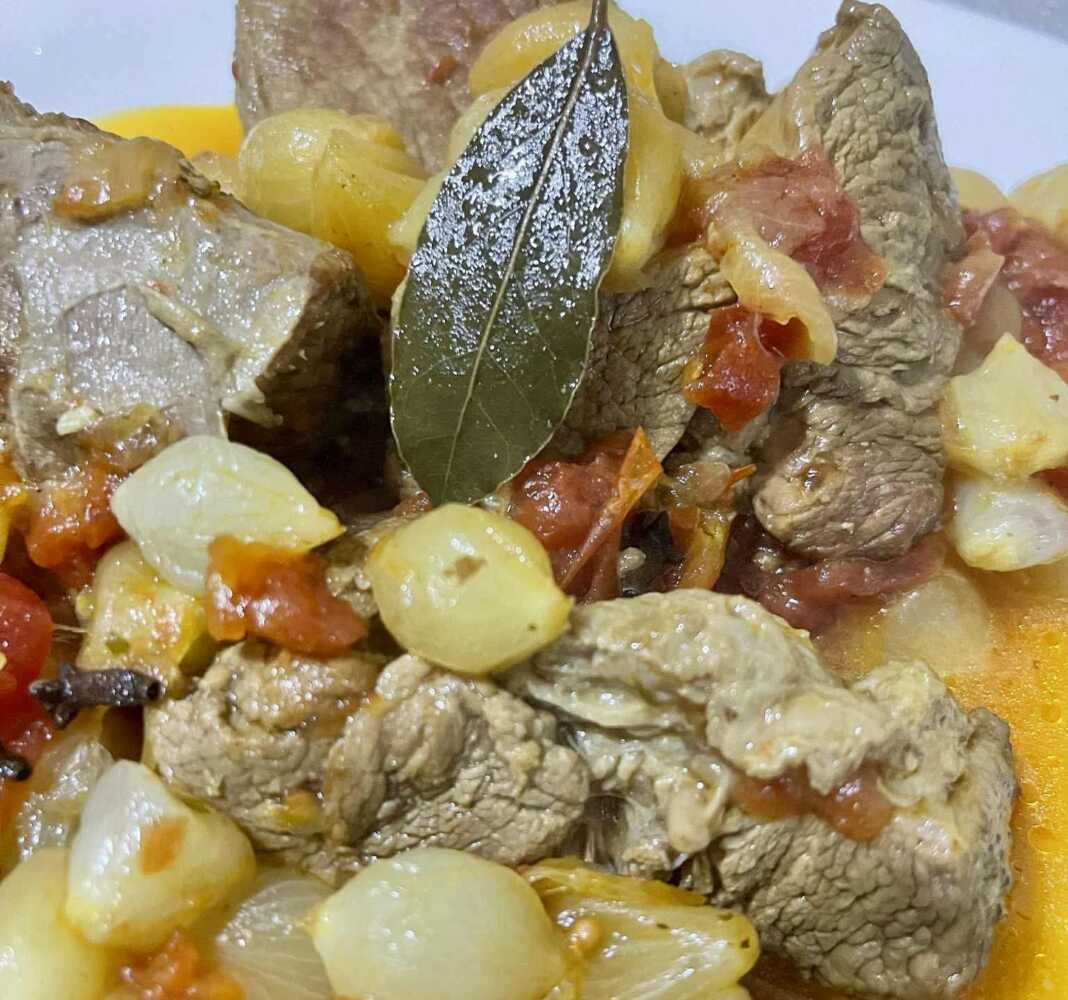 παραδοσιακό μοσχαράκι στιφάδο, όπου τα κρεμμυδάκια είναι ολόκληρα και μελωμένα μέσα σε μια πλούσια κόκκινη σάλτσα.