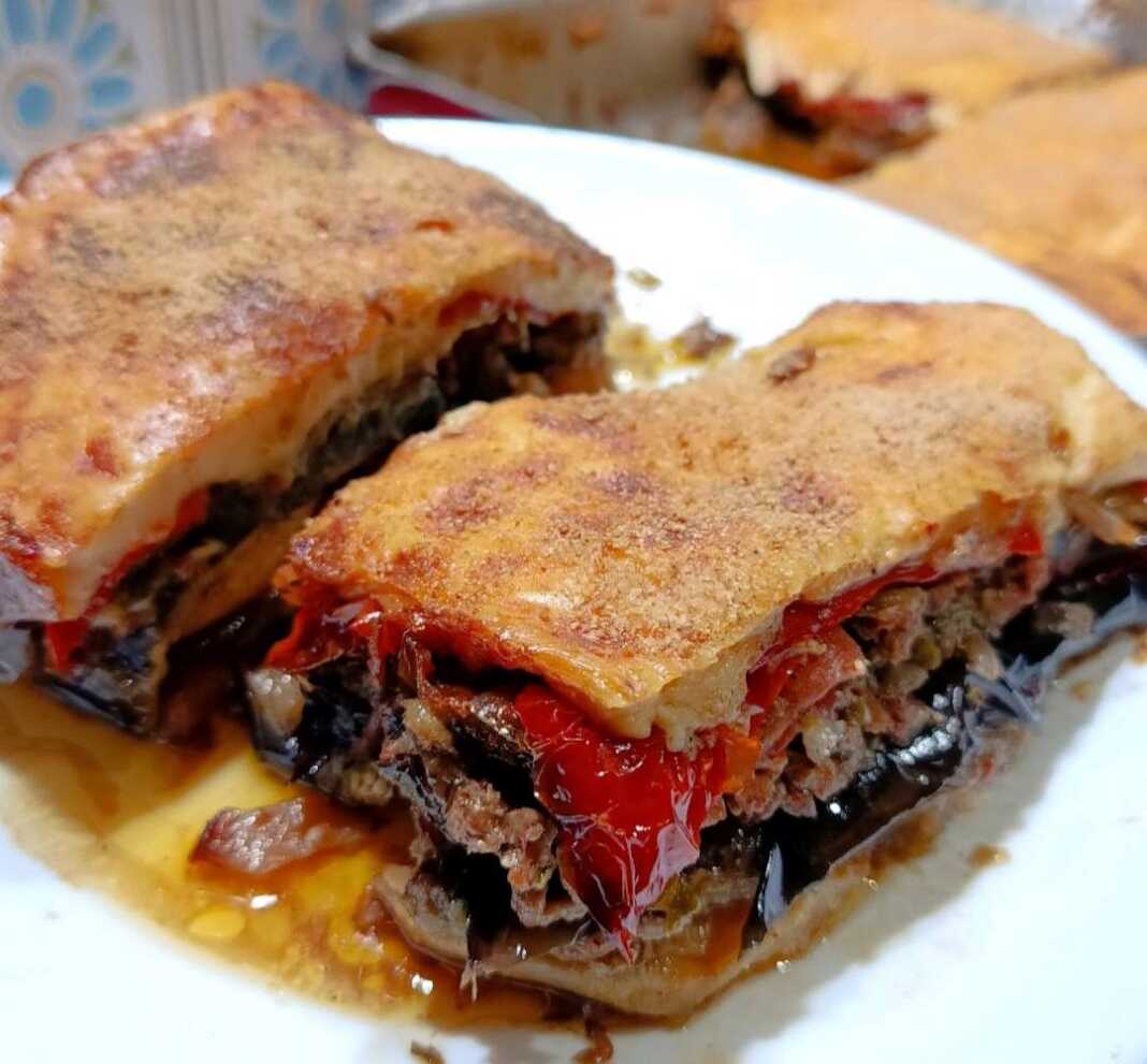 Ένα ταψί με λαχταριστό, καλοψημένο μουσακά με χρυσαφένια μπεσαμέλ και πλούσιες στρώσεις λαχανικών.