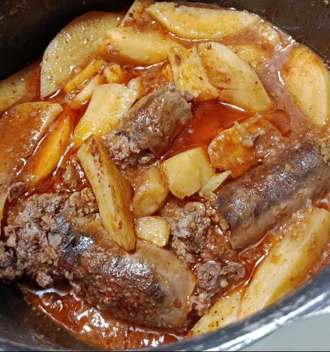 Ένα παραδοσιακό πιάτο με κομμάτια μπάμπως και μελωμένες πατάτες γιαχνί, μέσα σε πλούσια κόκκινη σάλτσα.