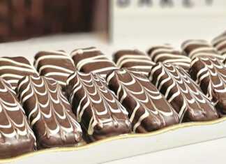 Σειρές από μικρά σαντουιτσάκια μπισκότου καλυμμένα με σοκολάτα γάλακτος και διακοσμημένα με γραμμές λευκής σοκολάτας.