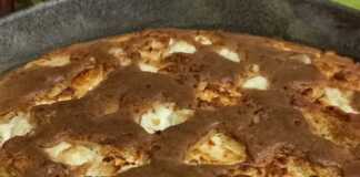 Μια χρυσαφένια καλαμποκόπιτα μέσα σε στρογγυλό ταψί, με λιωμένα κομμάτια φέτας στην επιφάνεια και τραγανή κρούστα.