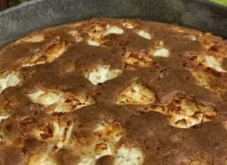 Μια χρυσαφένια καλαμποκόπιτα μέσα σε στρογγυλό ταψί, με λιωμένα κομμάτια φέτας στην επιφάνεια και τραγανή κρούστα.