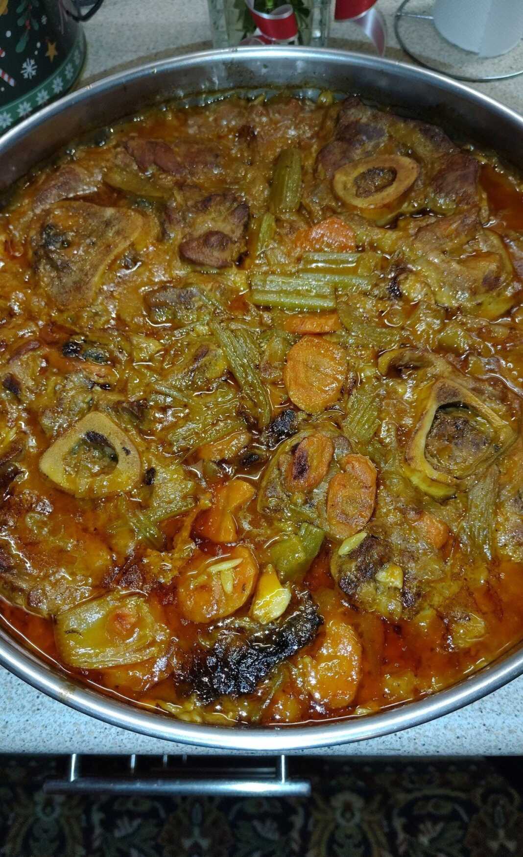 Ένα ταψι με μελωμένο με λαχανικα και τρυφερό οσομπούκο που λιώνει, μέσα σε πλούσια κόκκινη σάλτσα με καρότα.