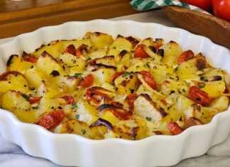 Ένα ταψί με ροδοκοκκινισμένες πατάτες φούρνου, καραμελωμένα κρεμμύδια και ψημένα ντοματίνια, καλυμμένα με πλούσια λιωμένη μοτσαρέλα.